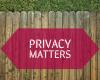 A wooden fence with a small amount of grass beyond it. A caption in a red box over the fence reads "Privacy Matters."