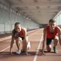 men and woman in red tank top is ready to run on track field