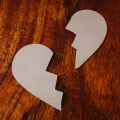 broken heart cardboard on brown wooden table top